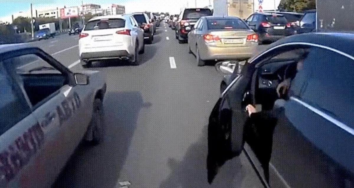 Coincé dans les embouteillages, il ouvre sa portière pile au moment où une moto remonte la file